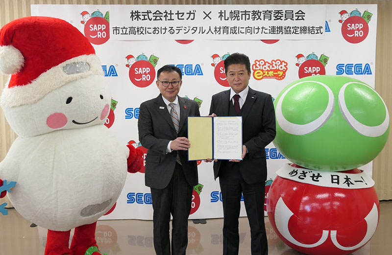 (左から、札幌の学校教育キャラクター「ゆっぽろ」、札幌市教育委員会檜田英樹教育長、セガ瀬川隆哉上席執行役員、セガのキャラクター「ぷよぷよeスポーツくん」)
